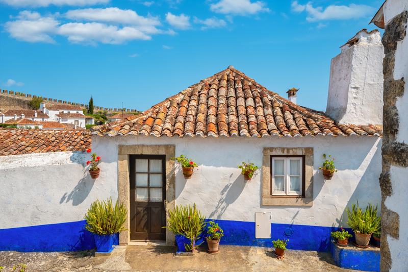 Facade of small stone house in medieval Obidos, Portugal